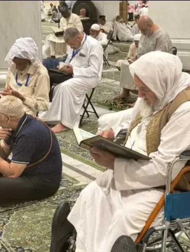 Visiteurs lisant le Coran à La Mecque